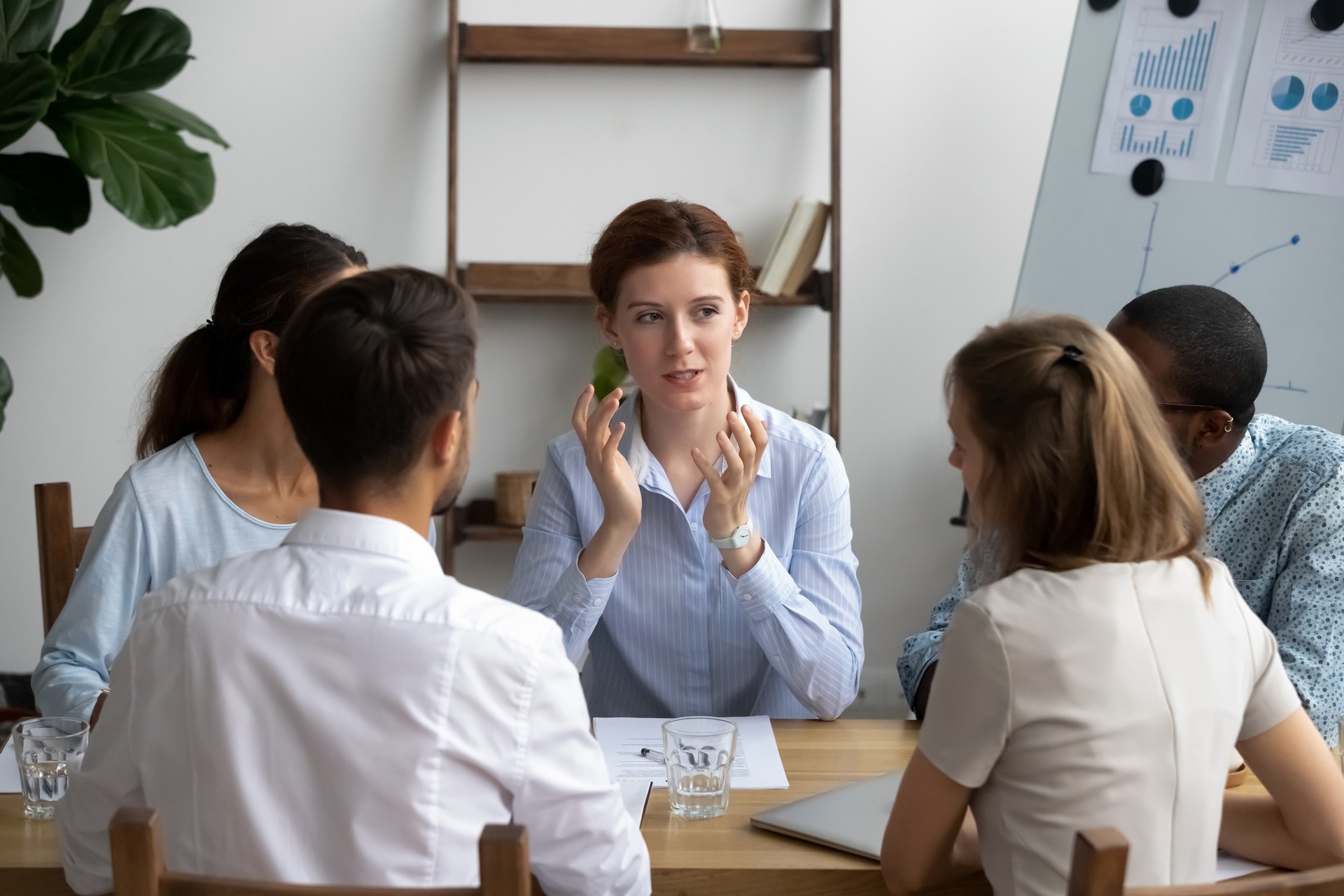 Five businesspeople brainstorming during briefing in boardroom